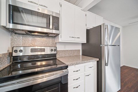 A kitchen with a stainless steel oven and microwave.