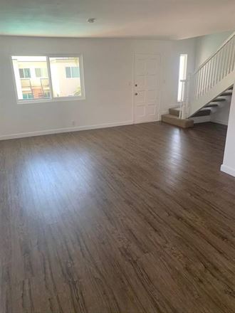 an empty living room with a hard wood floor