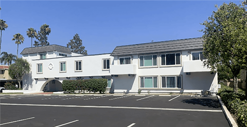 a white building with a parking lot in front of it