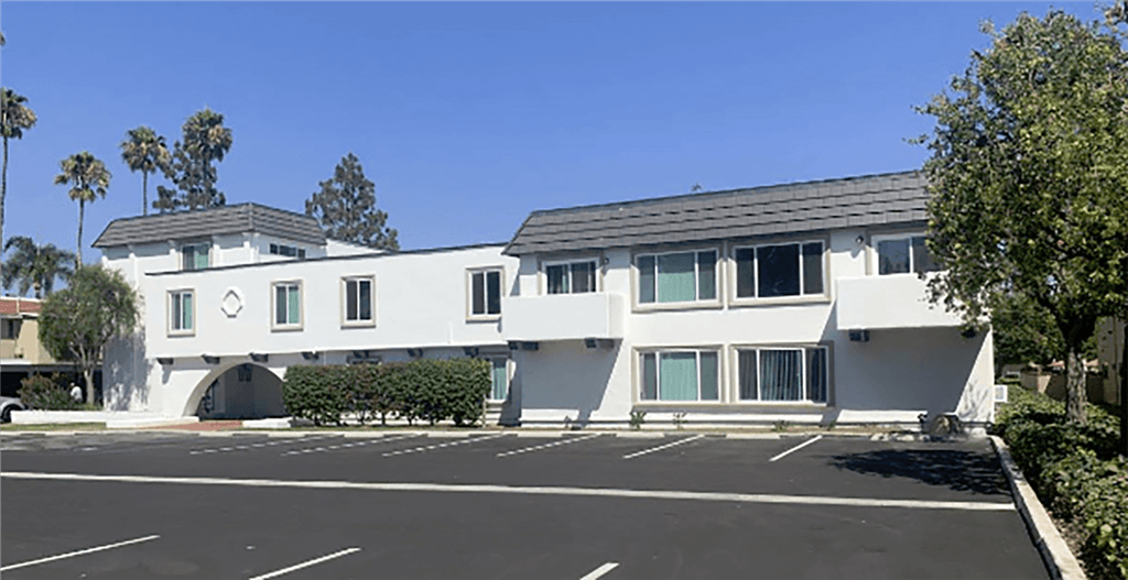 a white building with a parking lot in front of it