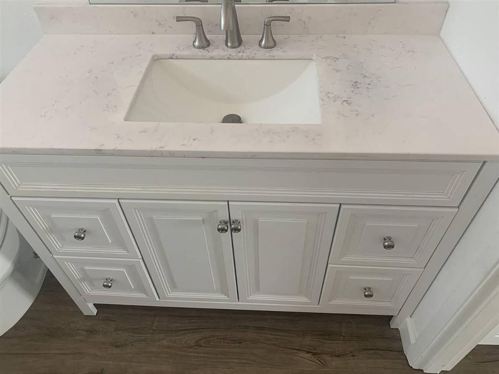 a white bathroom vanity with a sink and a mirror