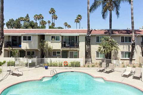 an apartment building with a swimming pool and palm trees