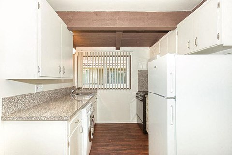 a white kitchen with white appliances and white cabinets