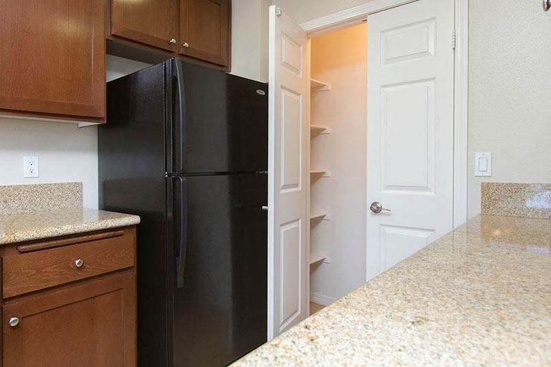 a kitchen with a black refrigerator and an open door