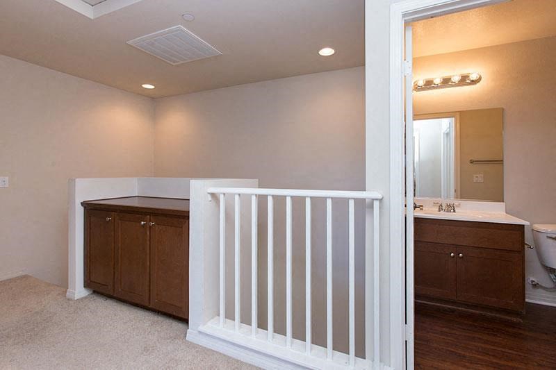 a bathroom with a white railing and a sink