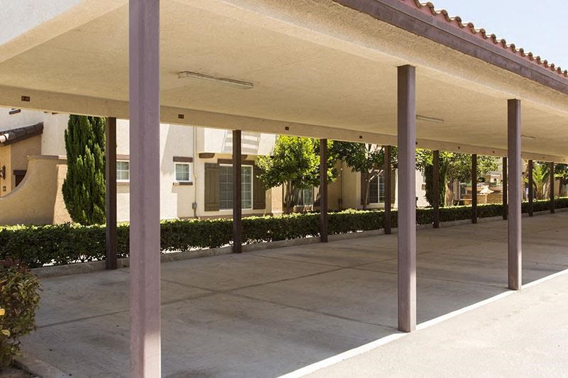 a covered parking lot with a building in the background