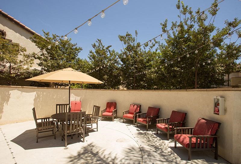 a patio with a table and chairs and an umbrella