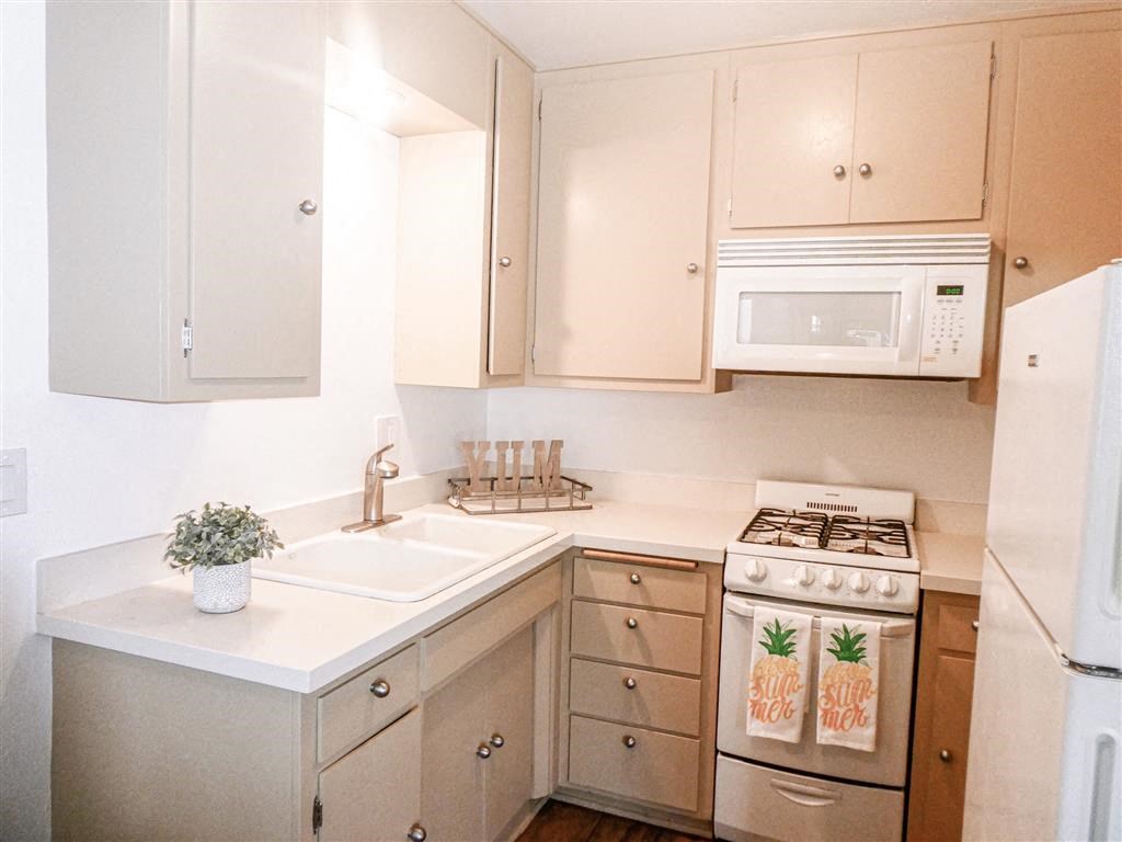 a kitchen with white cabinets and a stove and a microwave