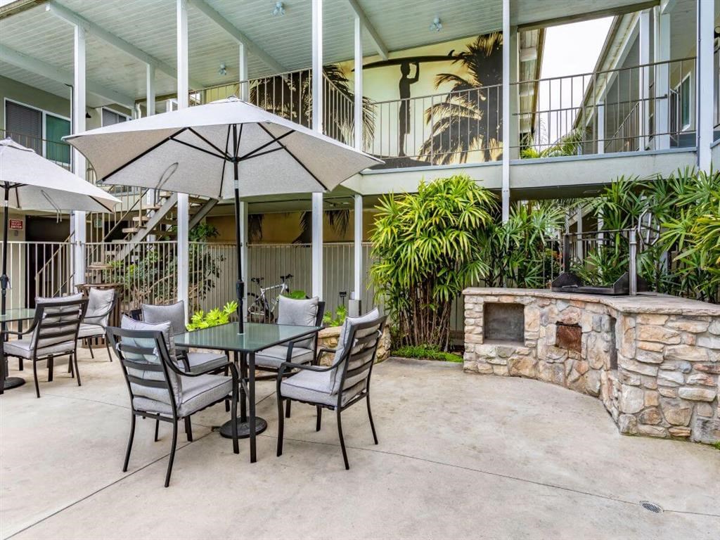 a patio with a table and chairs and a stone fireplace