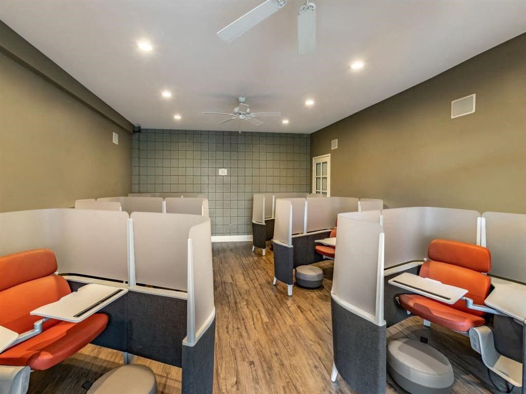 a small office with a row of chairs and tables