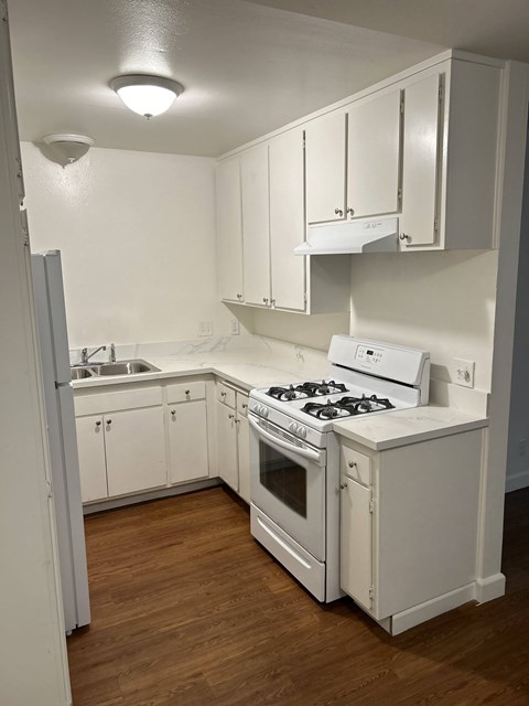 A white kitchen with a stove and oven.