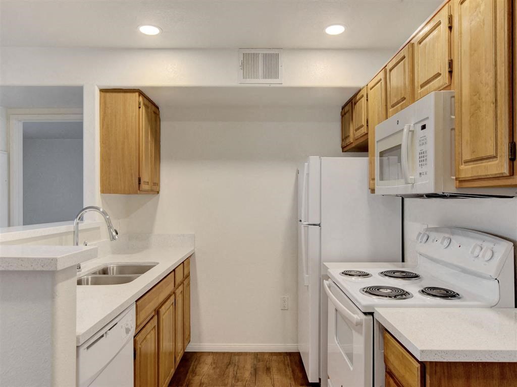 a kitchen with white appliances and wooden cabinets
