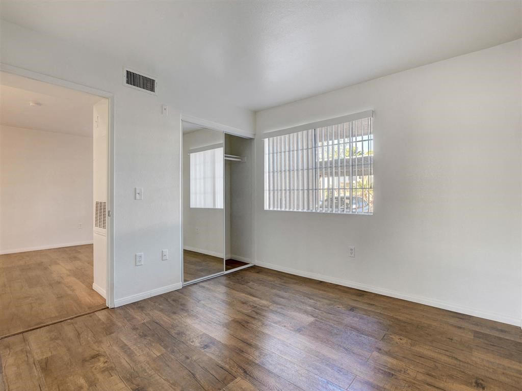 an empty living room with hardwood floors and a large window