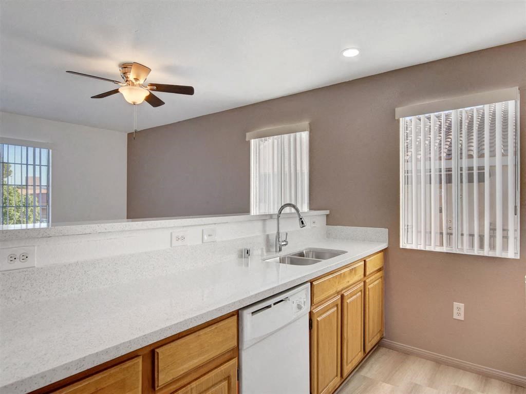 a kitchen with a sink and a ceiling fan