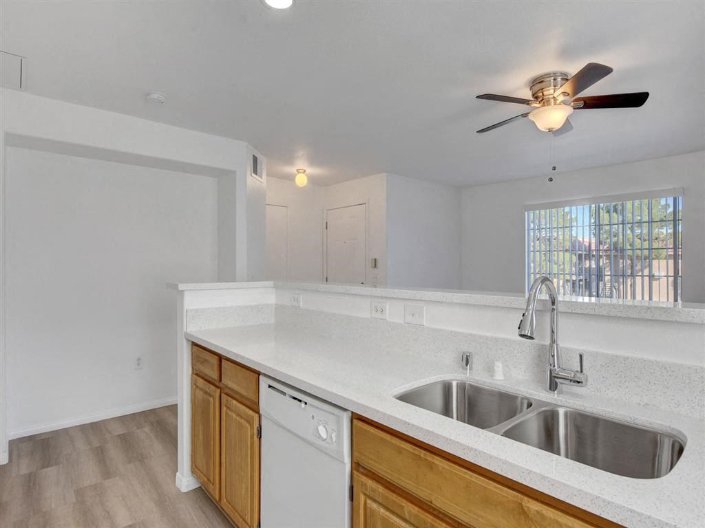 a kitchen with a sink and a ceiling fan