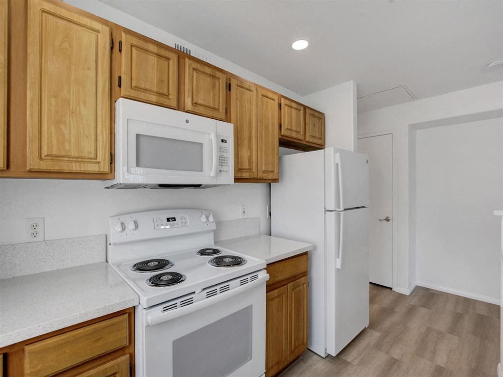 a kitchen with a white stove top oven next to a refrigerator
