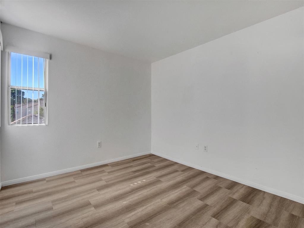 a bedroom with white walls and a window
