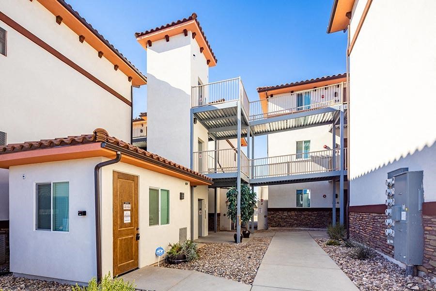 a walkway between two buildings with a sky background