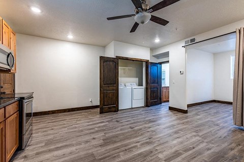 a kitchen and living room with a ceiling fan
