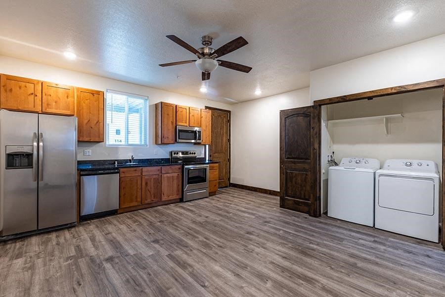 a kitchen with a stove top oven next to a washer and dryer