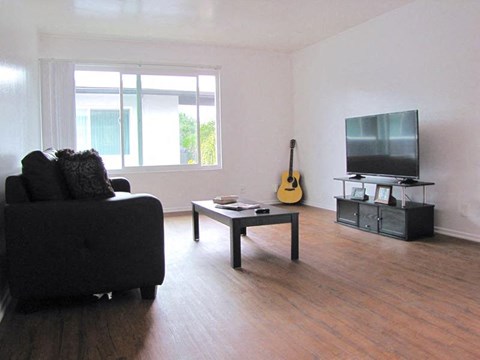 a living room with a couch a television and a guitar