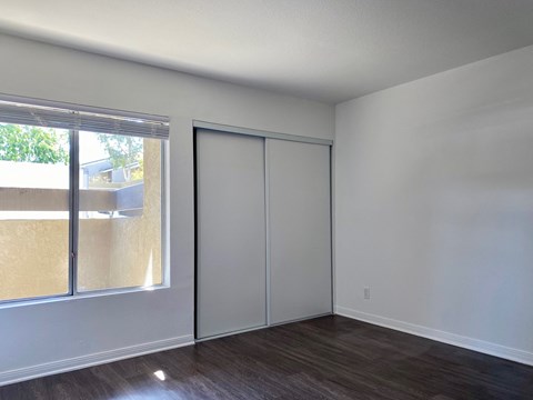 an empty living room with white walls and a window