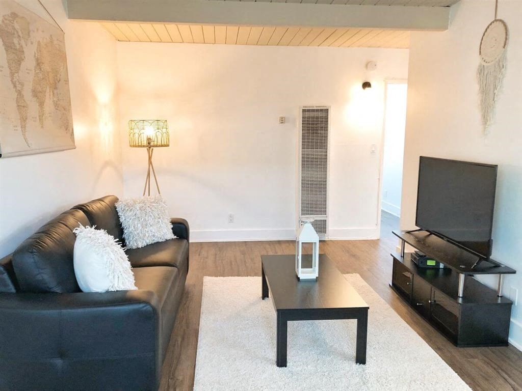 a living room with a leather couch and a television