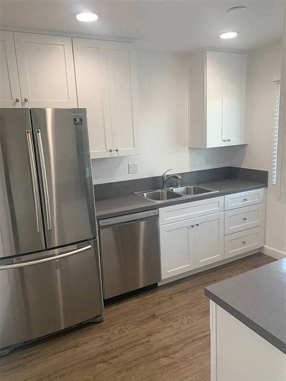 a kitchen with white cabinets and a stainless steel refrigerator and dishwasher