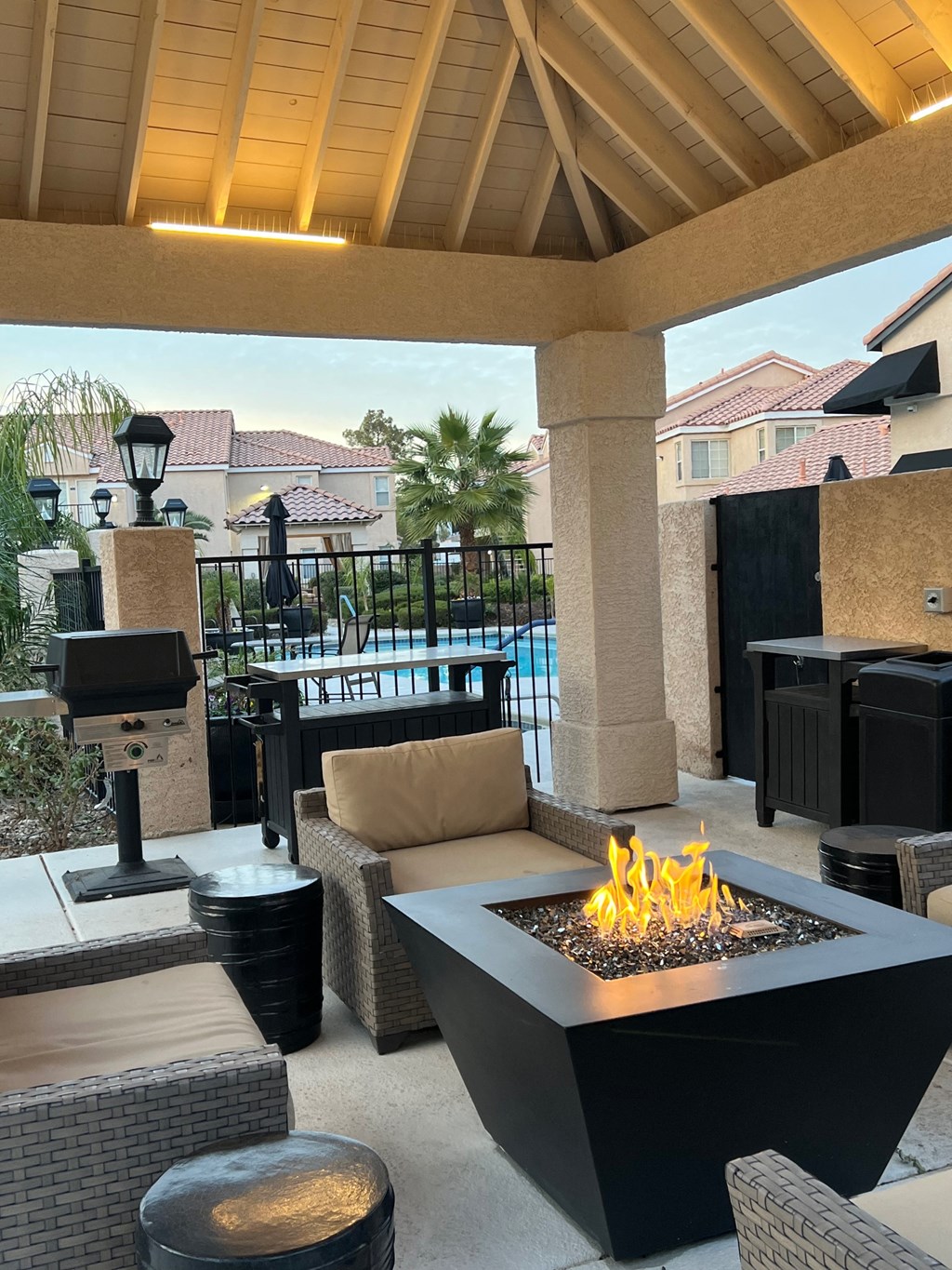 a patio with a fire pit and seating around it