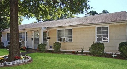 a yellow house with a yard and a tree