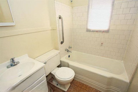 a bathroom with a toilet and a tub and a sink