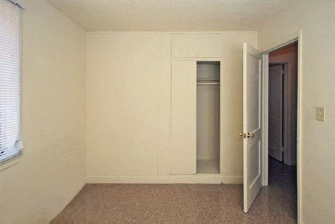 an empty room with a door and a closet