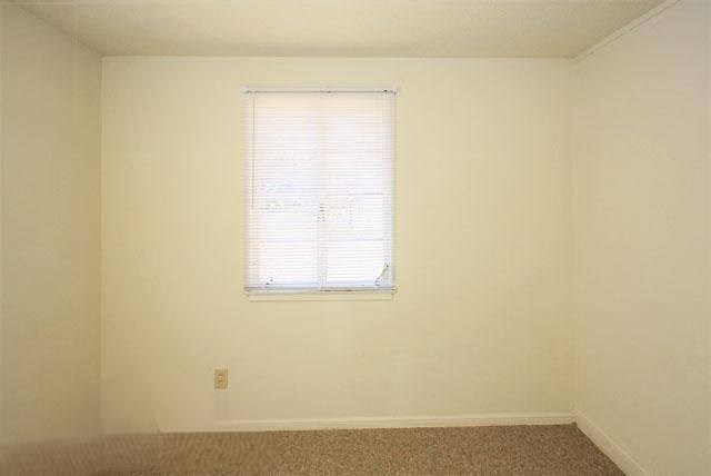 an empty room with a window and white walls