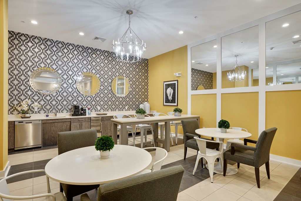 a dining room with tables and chairs and a kitchen