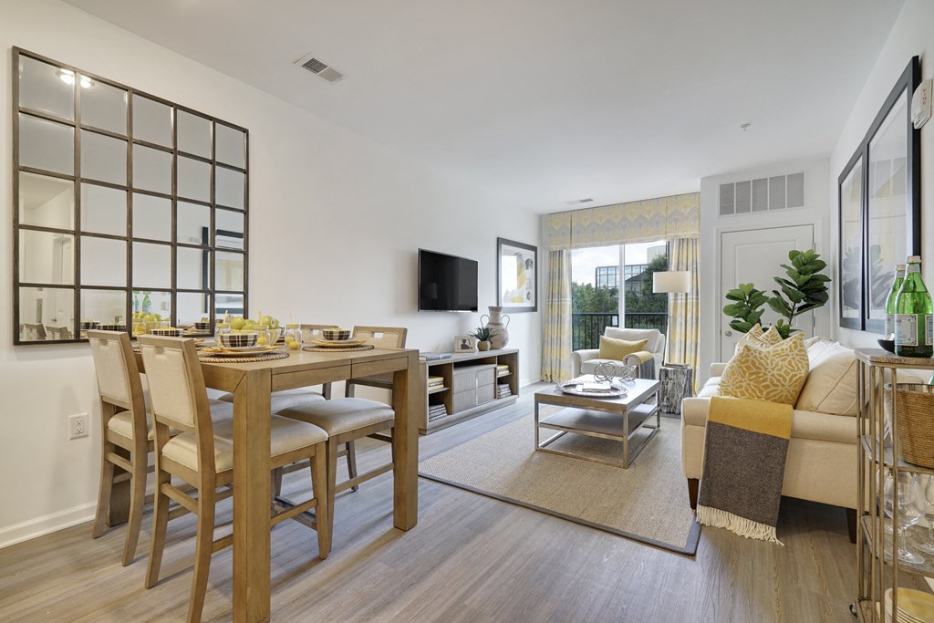 a living room and dining room with a table and chairs