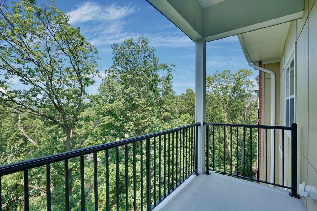 a balcony with a view of trees and a blue sky