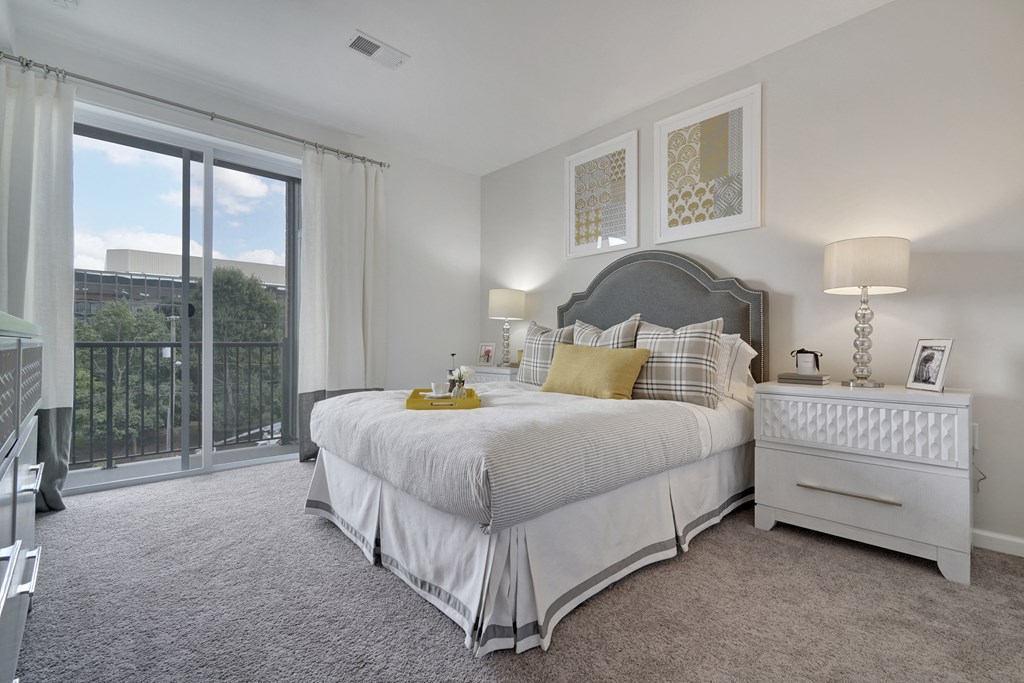 a white bedroom with a large bed and a balcony