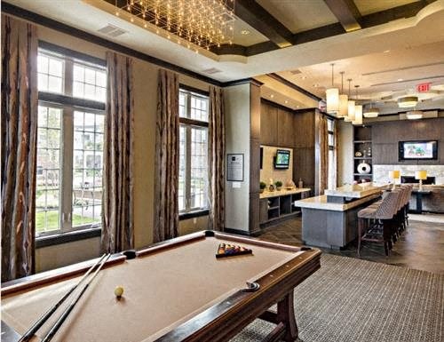 a game room with a pool table and a bar