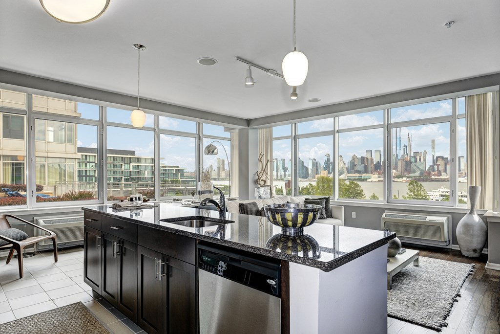 the view of the city from the kitchen and living room of an apartment