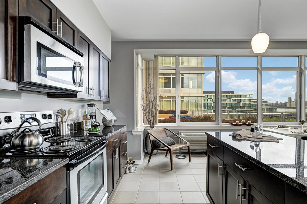 a kitchen with a large window and a stove and a sink