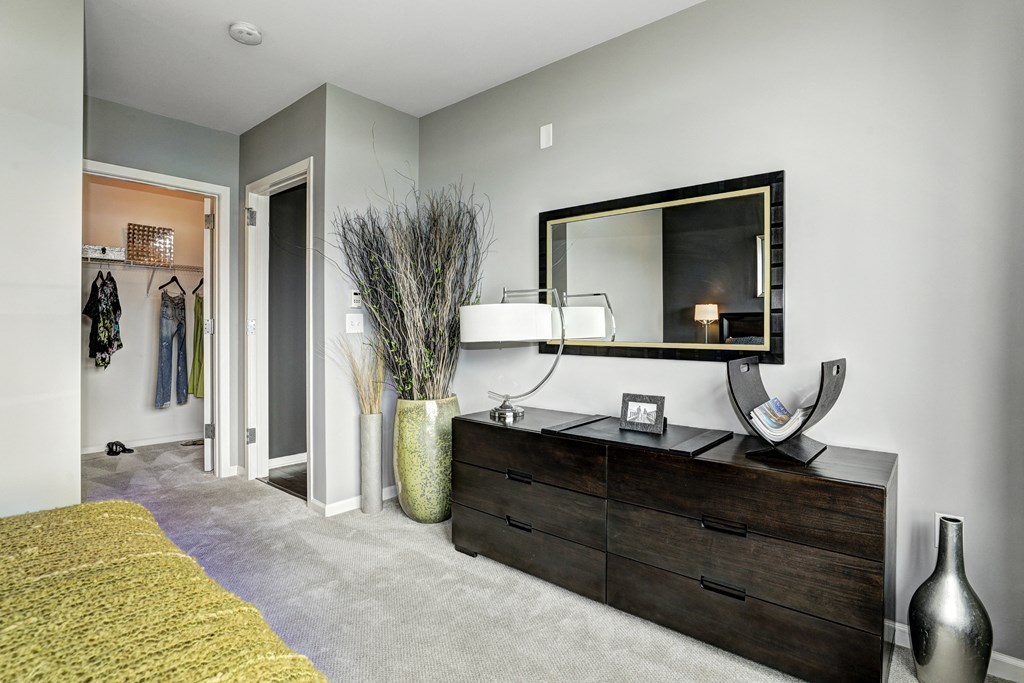a living room with a dresser and a mirror