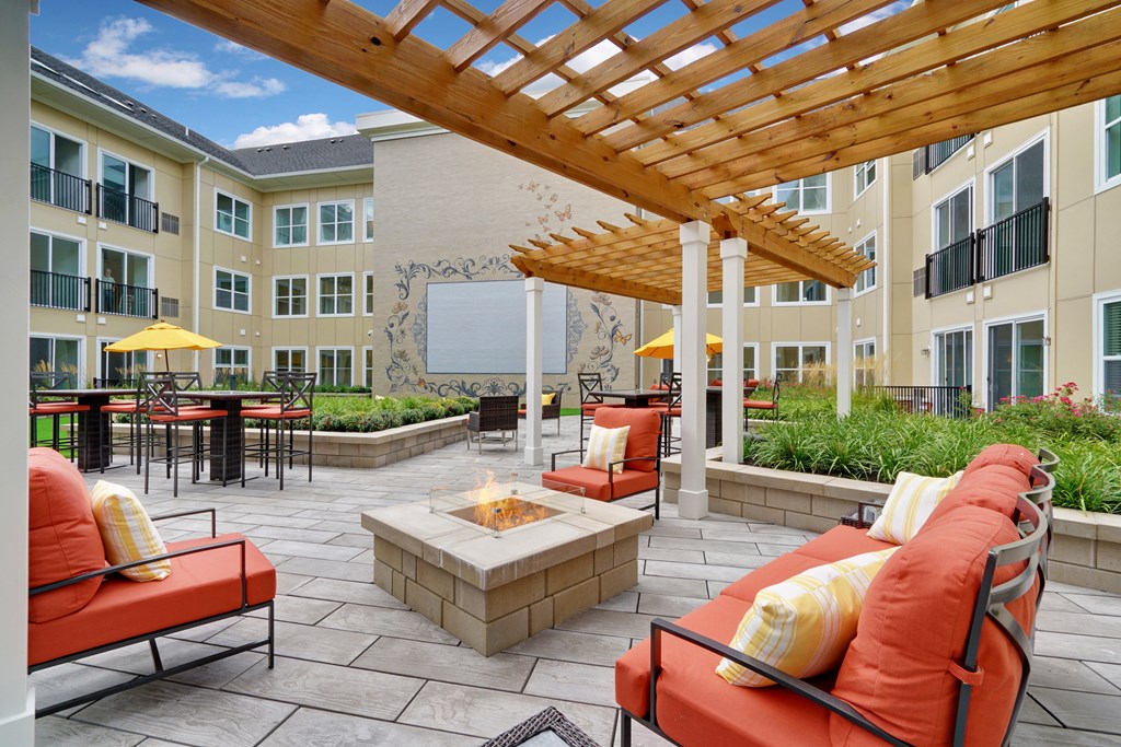 an outdoor patio with couches and chairs and a fire pit
