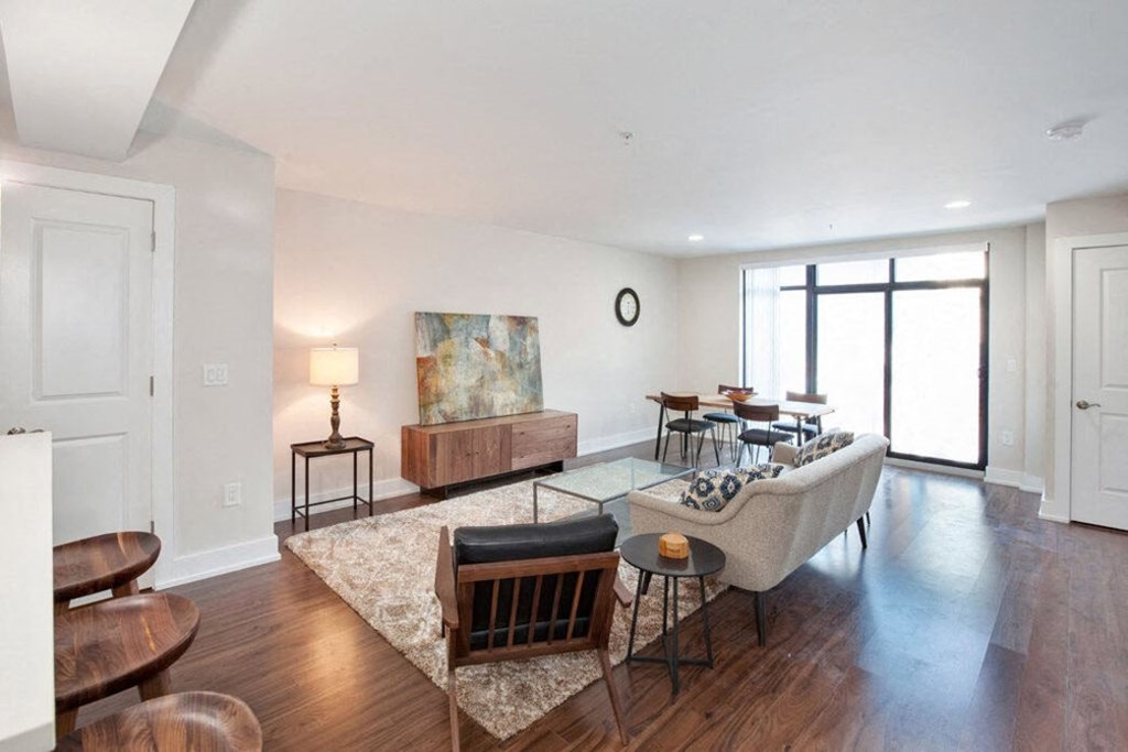 a living room with white walls and hardwood floors