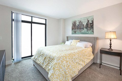 Bright bedroom with upholstered bed and nightstand at Park Bayonne Apartments, New Jersey, 07002