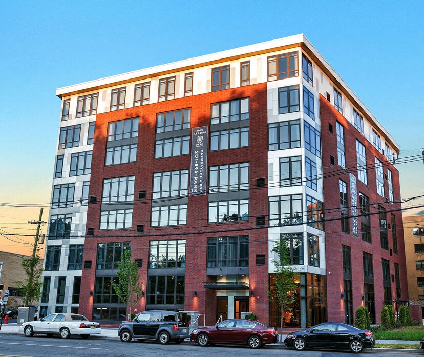a large brick building with many windows and cars parked in front of it