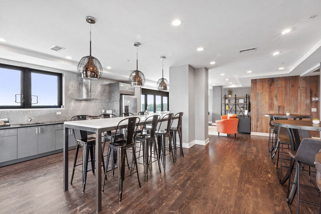 a kitchen with a long island with a bunch of chairs around it