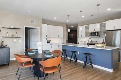 A modern kitchen with a dining table and chairs.