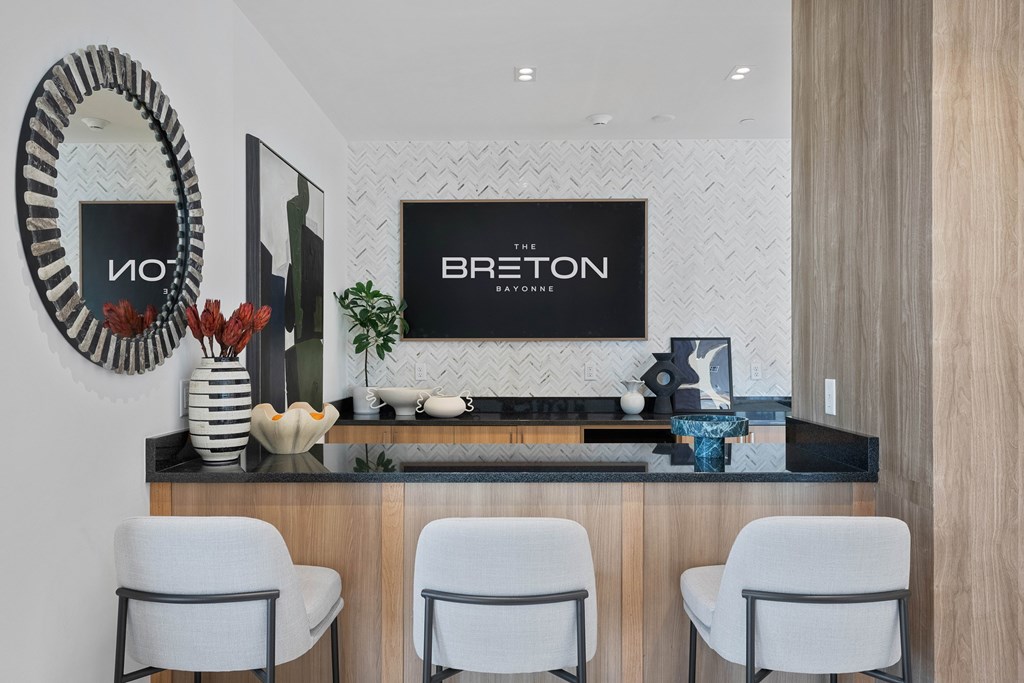 A modern salon with white chairs and a counter displaying the name "BRETON".