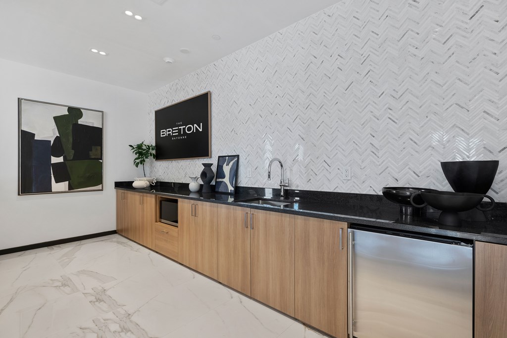 A modern kitchen with a wooden counter and a stainless steel refrigerator.