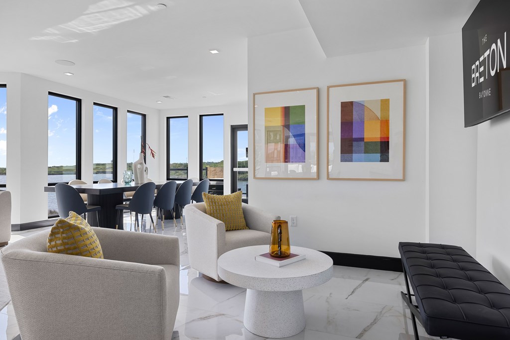 A modern waiting room with a white couch, chairs, and a coffee table.